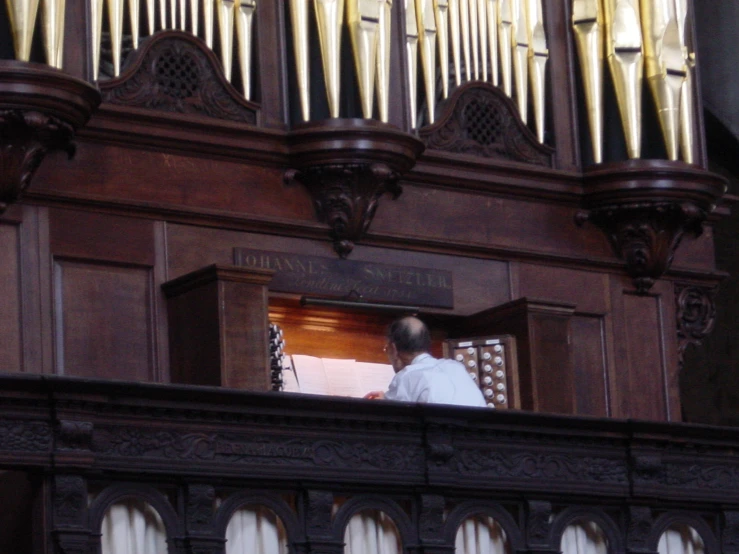 the pipe organ is brown in color with woodwork