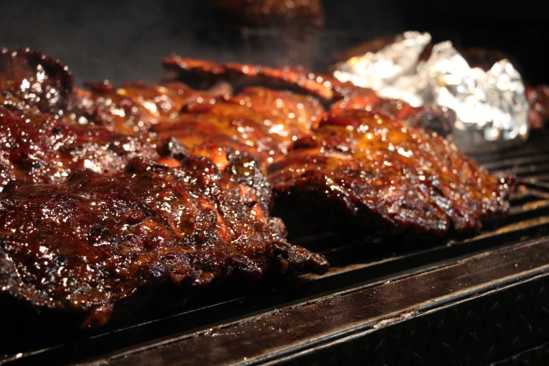 barbecue steaks cooking on the grill with bbq sauce