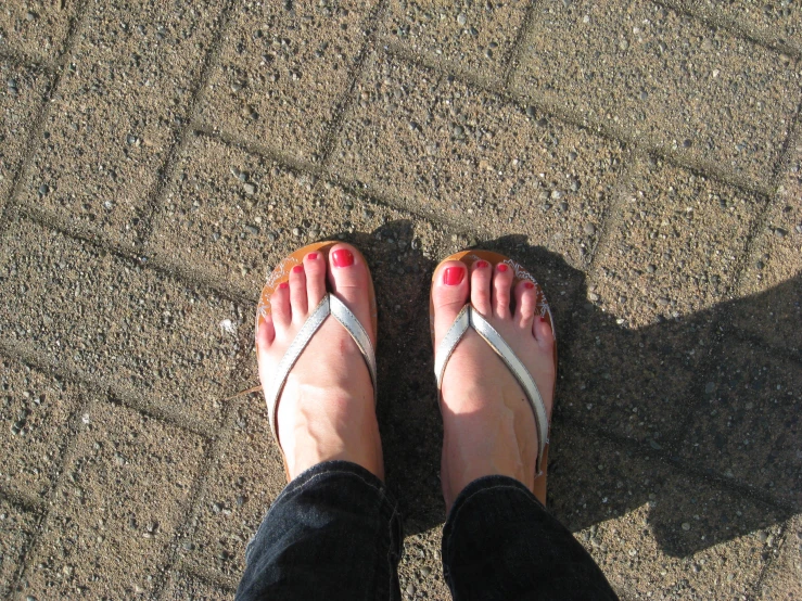 woman in flip flop sandals sitting down on the ground