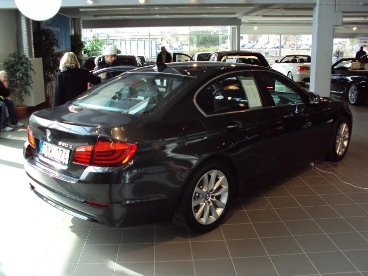 a black car parked in front of people