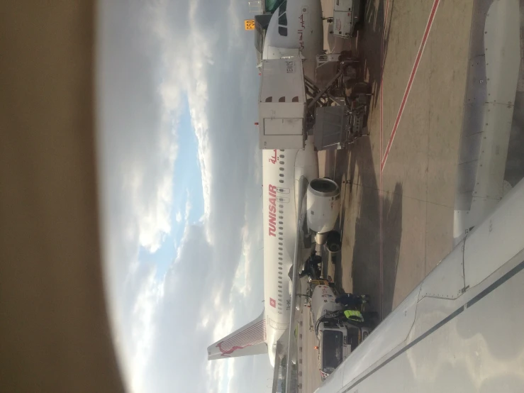 a jumbo jet sits parked next to an airplane on the runway