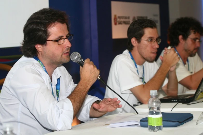 several men at a table talking with microphones