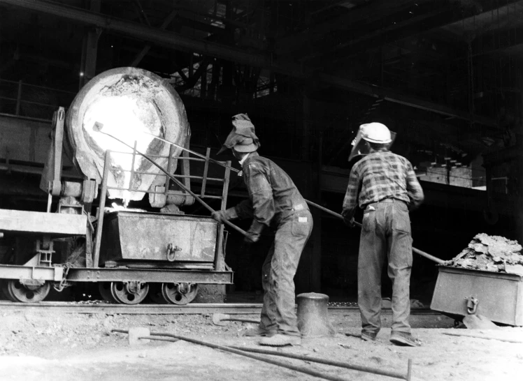 two men working at a factory with machinery