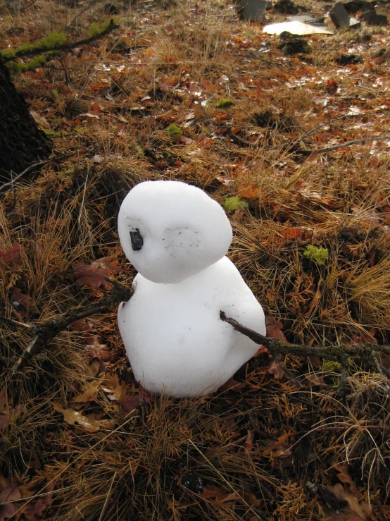 a snowman with a stick in the woods