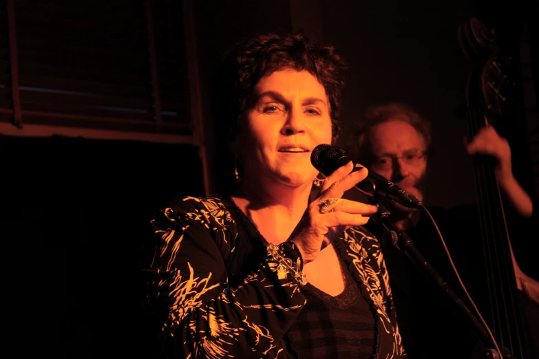 a woman is standing up and holding a microphone