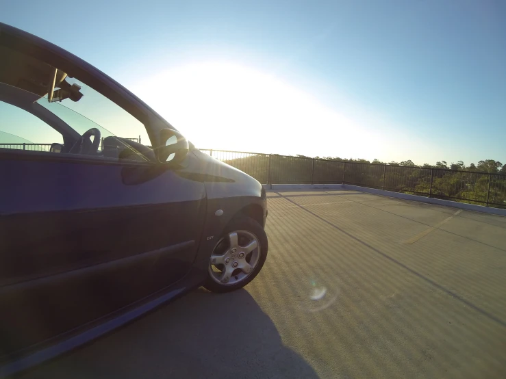 a person in a small blue car driving through the countryside