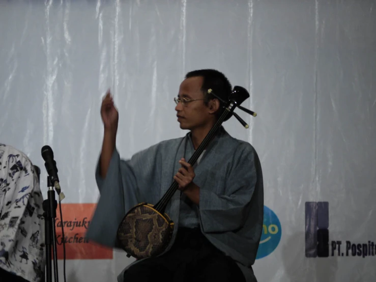 a person standing and holding a music instrument on a stage