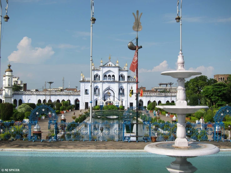 a white castle on a clear day next to blue benches and water