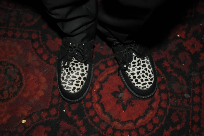 the feet are shown in black and white leopard print shoes