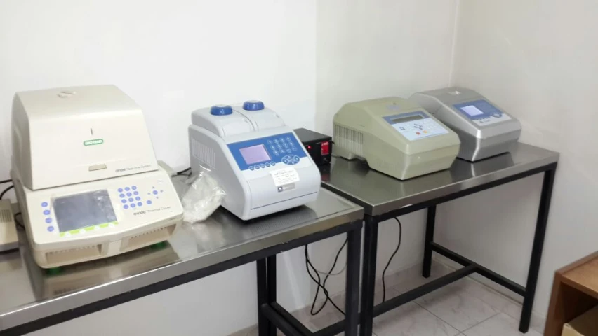 three electronic machines sitting on a metal table