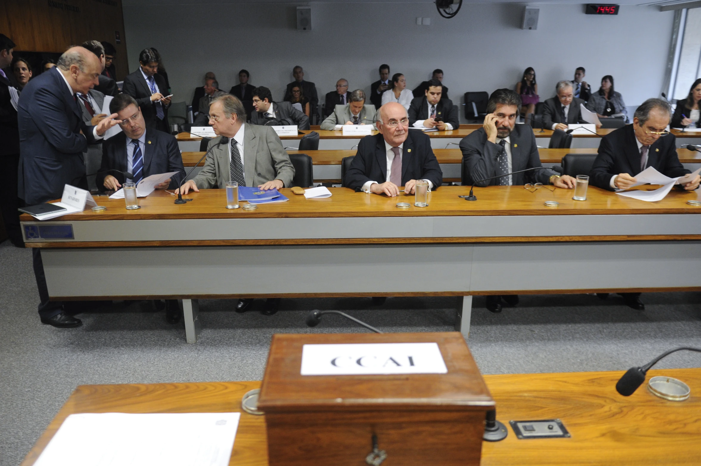 men sit in an office while listening to speakers