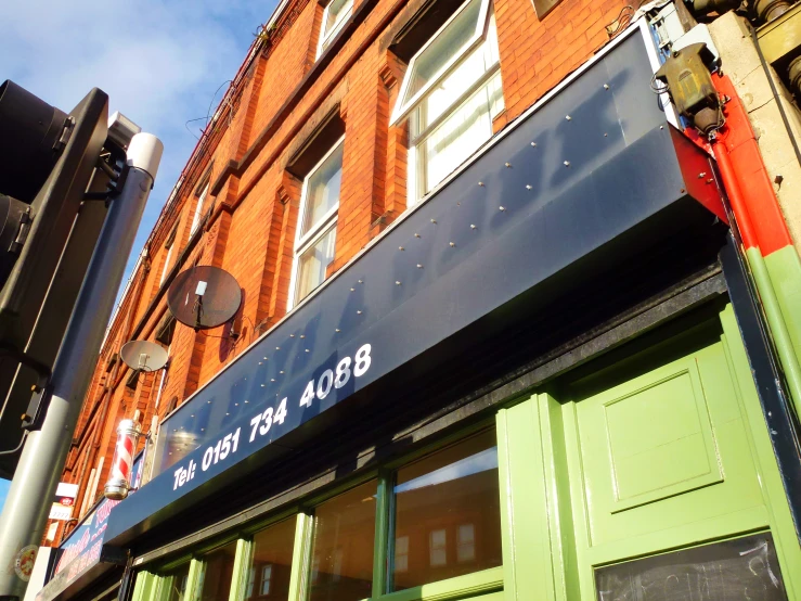 a building with green shutters and signs for the business