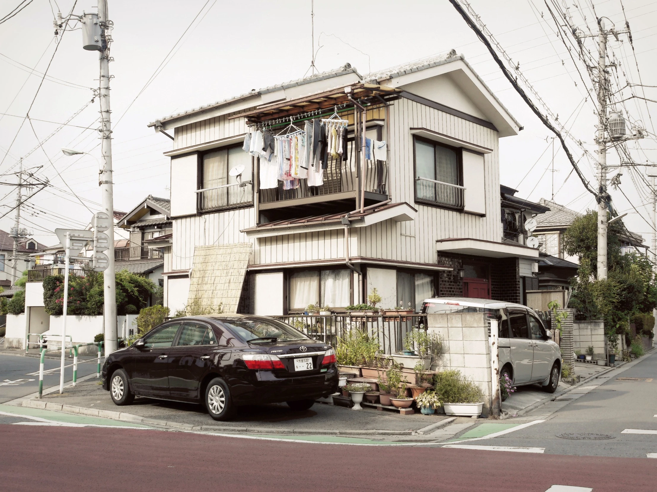 the car is parked on the street by the small house