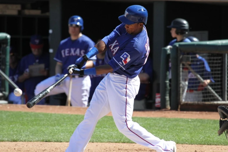 a baseball player is swinging at a ball while the umpire stands behind him