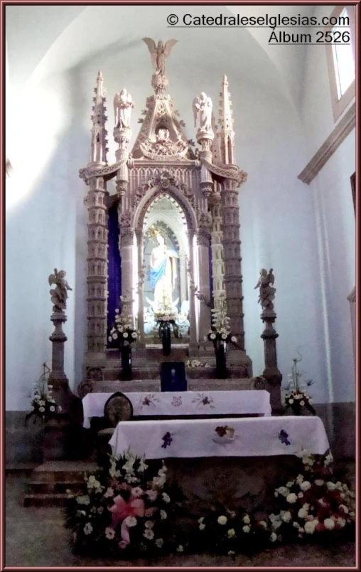 a statue inside of a church that is decorated with flowers