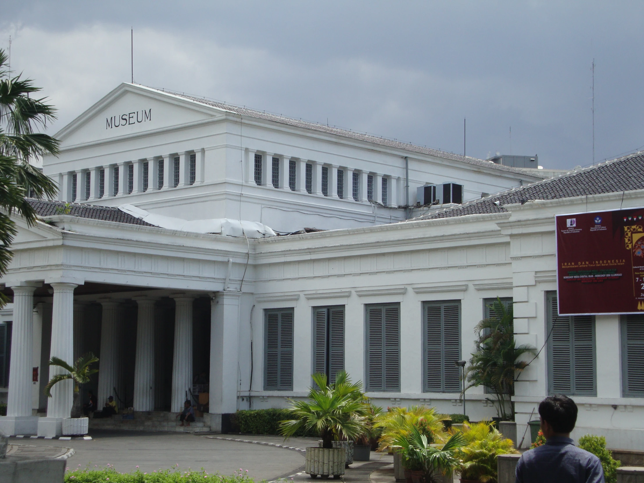 people standing outside a white building on a cloudy day