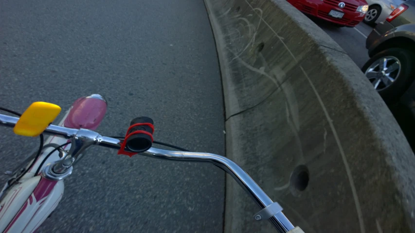 a red car parked next to a white and pink motor scooter