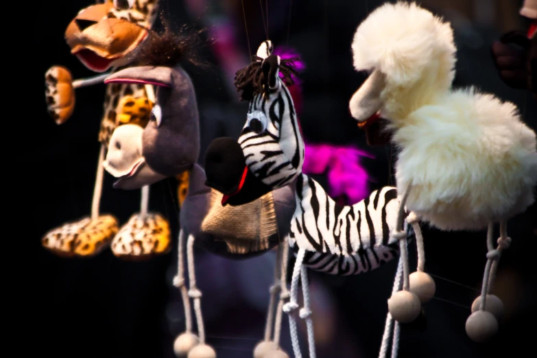 several different stuffed animals hanging on strings