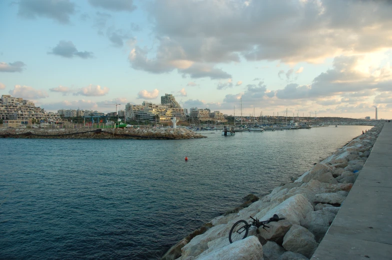 view of sea with sky and clouds and a bike on the curb