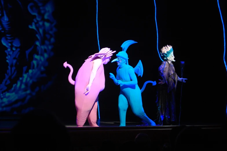 three performers in blue costumes and one with an elephant