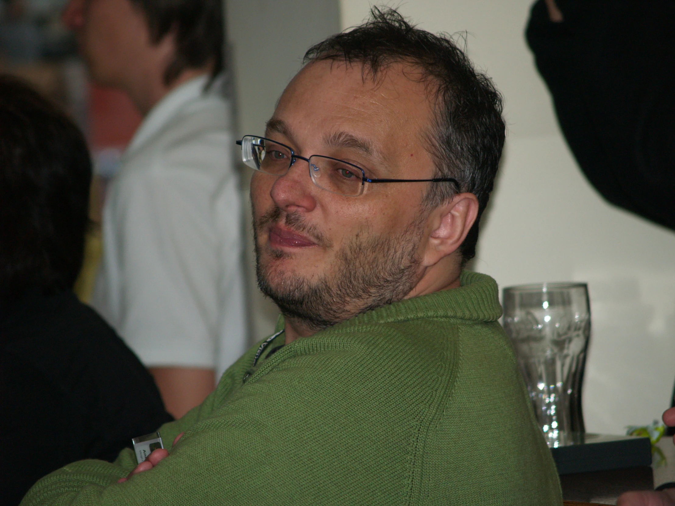 a man that is sitting down wearing some glasses