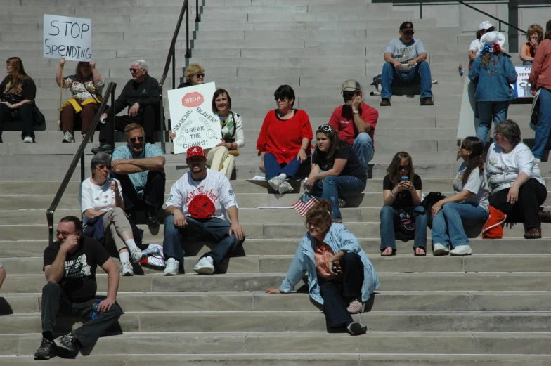 a large group of people are sitting on the steps