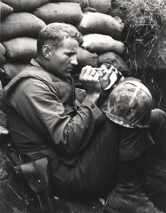 a man kneeling next to piles of bags eating a snack