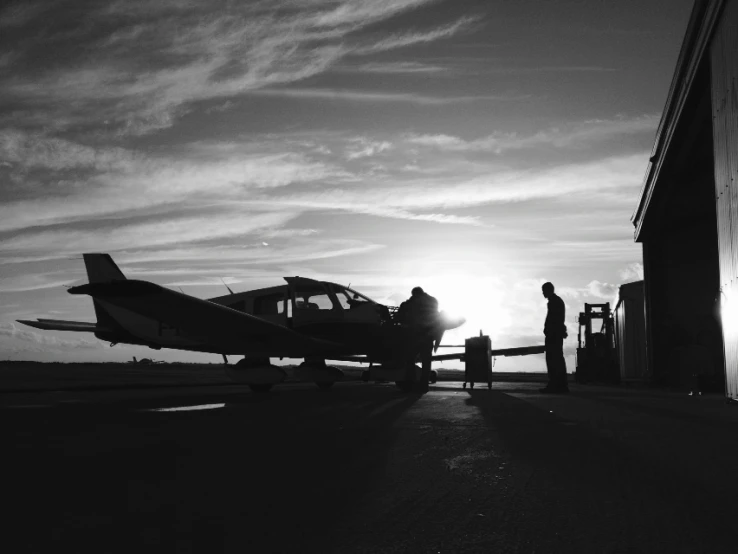 an airplane is on a runway near two people