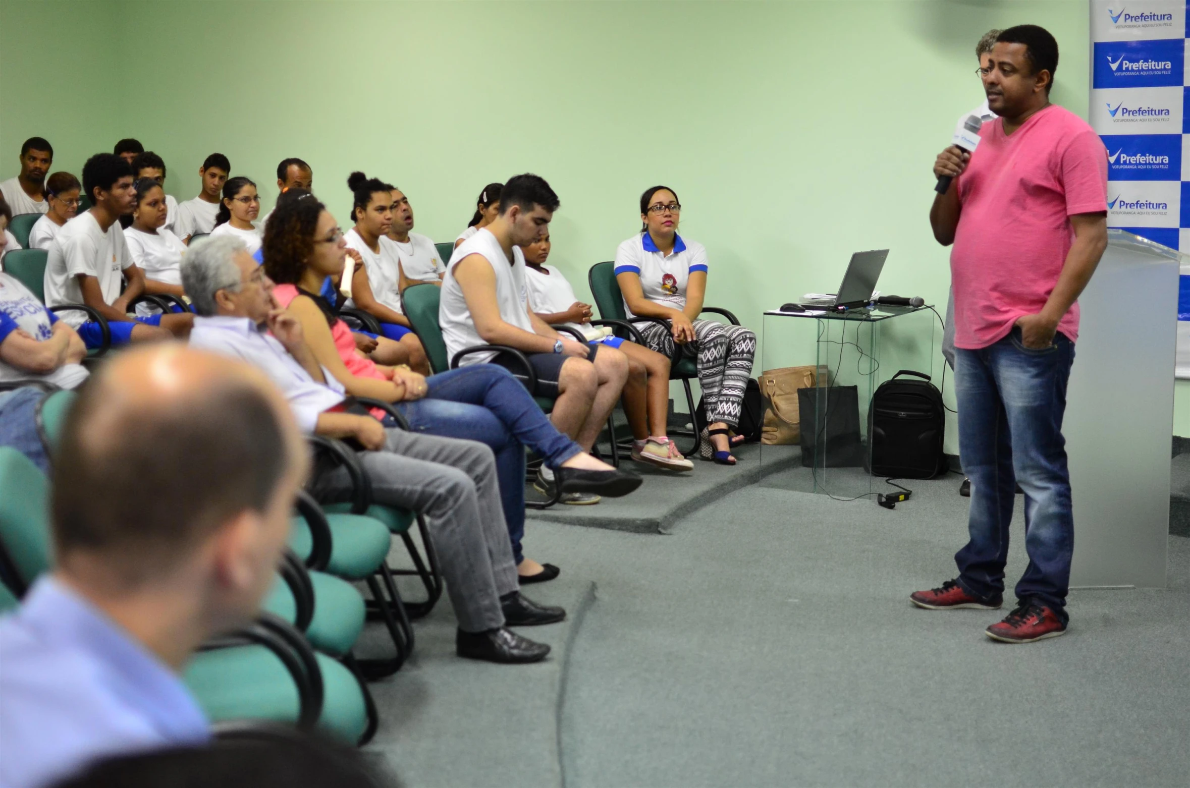 man presenting his work to large audience in a conference hall