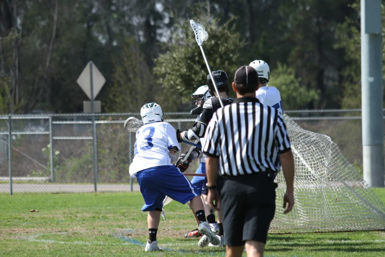 the men are playing lacrosse on the field