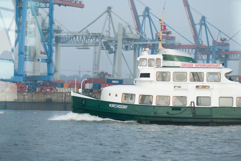 a green and white boat in the water