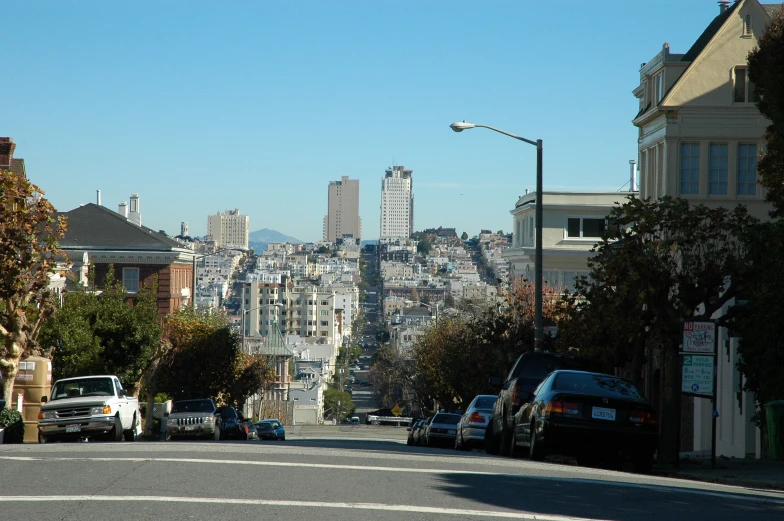 a cityscape and a bunch of cars parked near the side walk