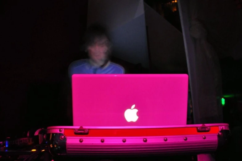 a woman sitting on a laptop computer in the dark