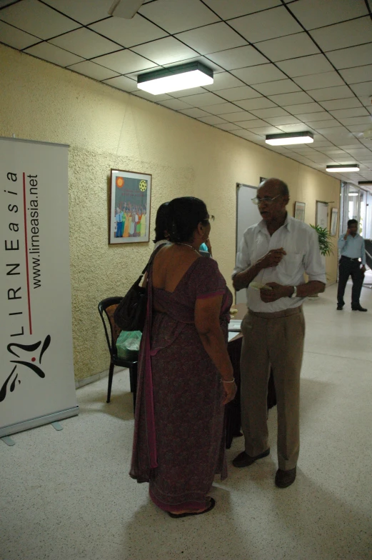 two people standing in a room holding out papers