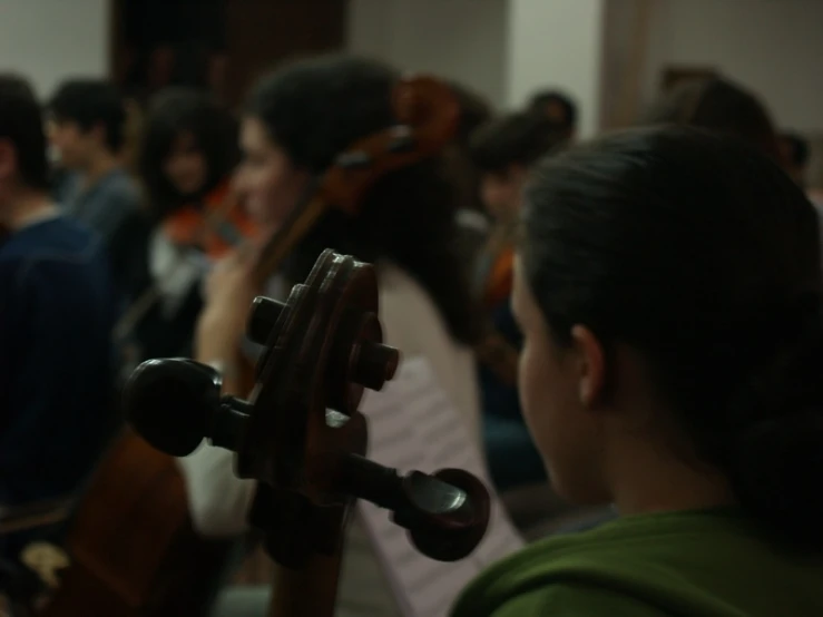the girl is looking at an instrument in the crowd