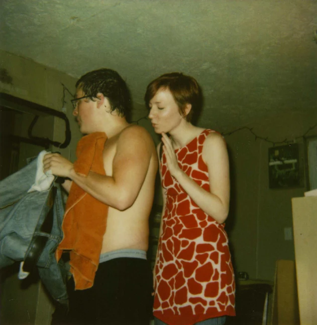 two people in a room standing with clothes