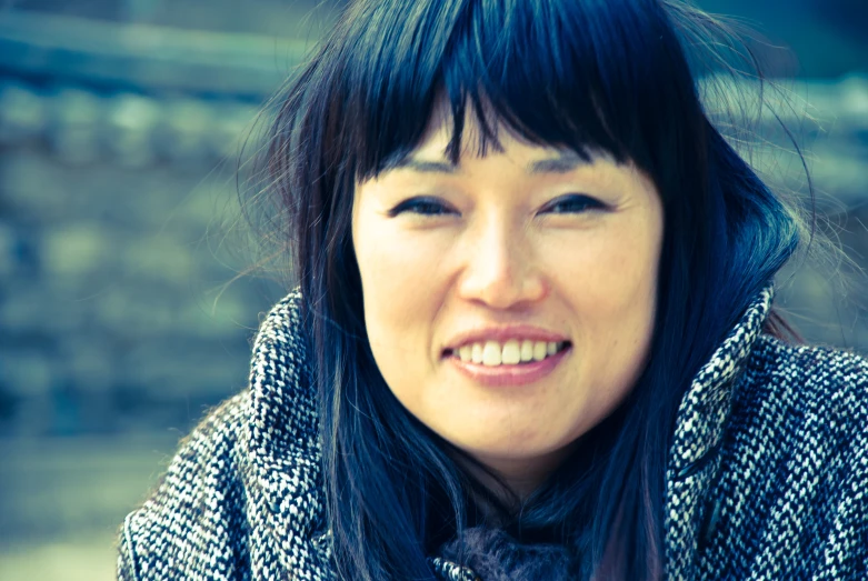 the woman with black hair smiles at the camera