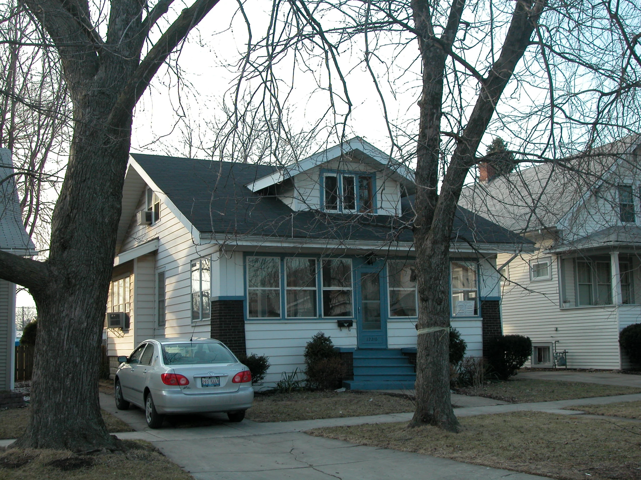 a car parked on the sidewalk in front of two houses