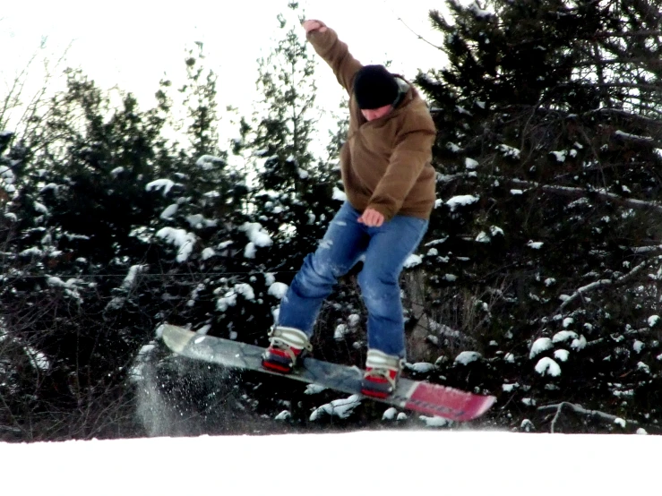 a man on a snow board does a trick in the air