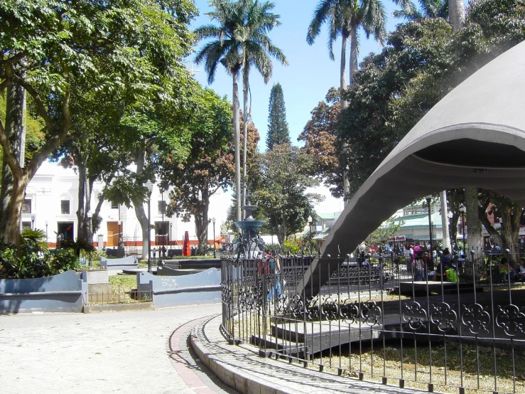 an outdoor play area with a circular metal structure and steel fence surrounding the area