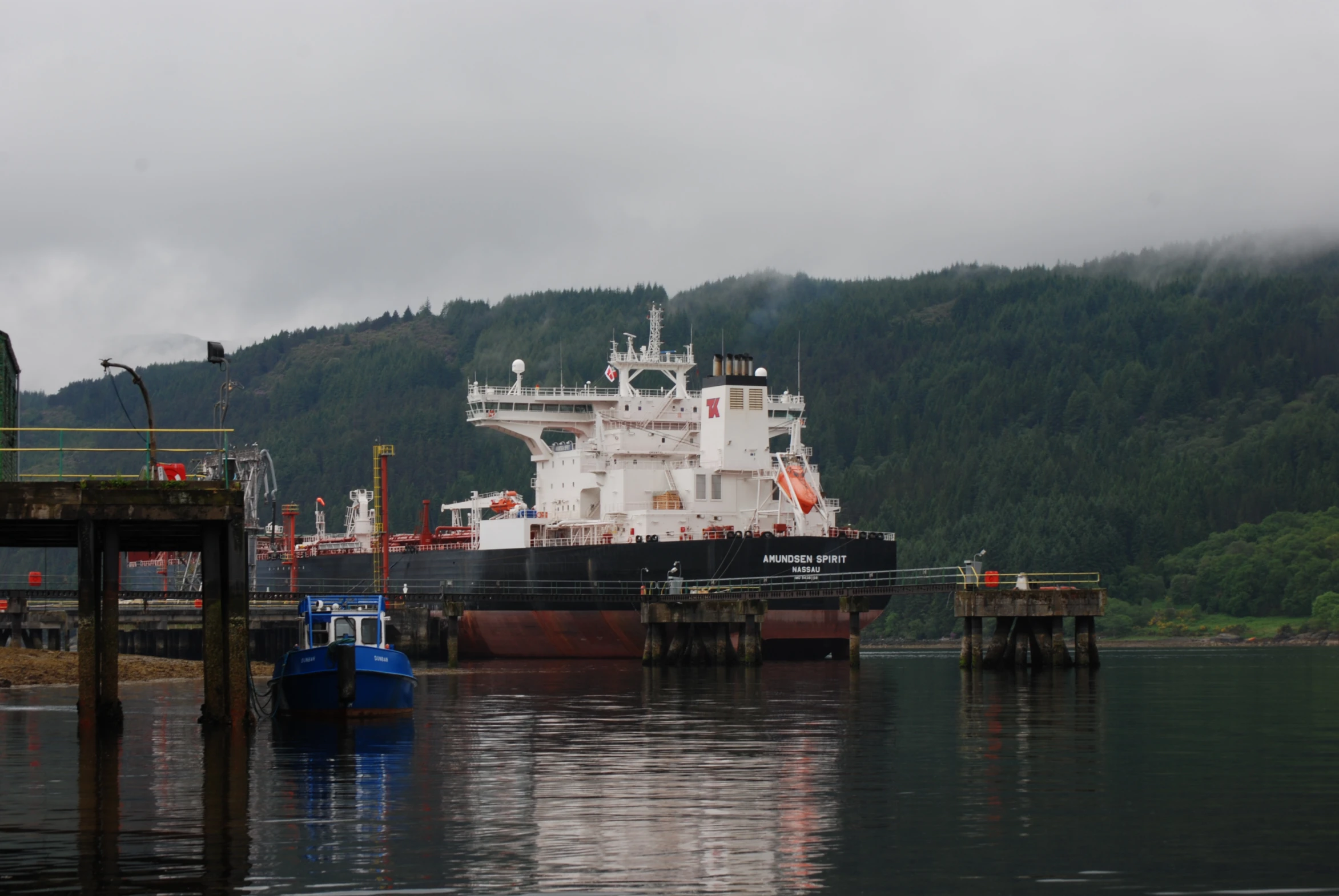 a large ship sits next to a dock on the water