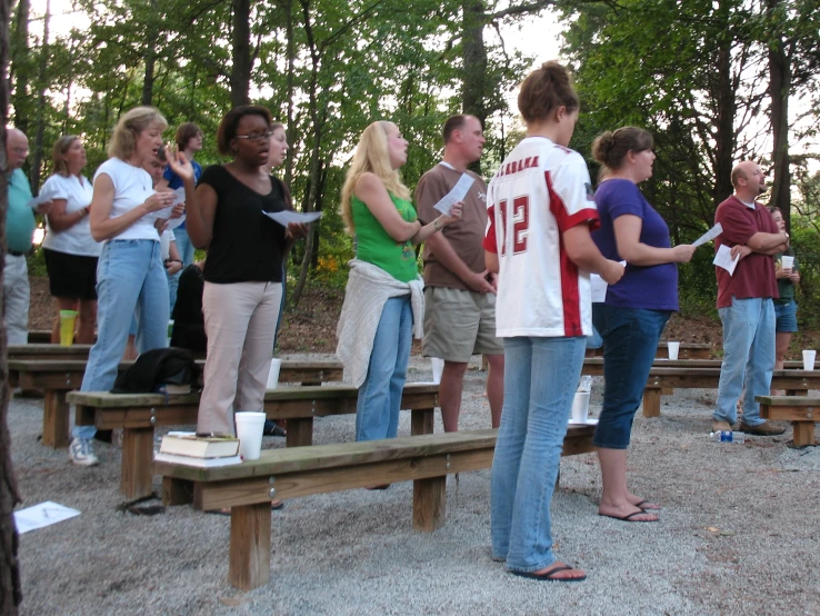 a group of people standing around each other in a forest