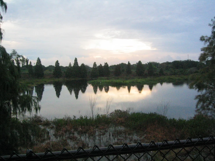 a lake that is sitting next to a fence