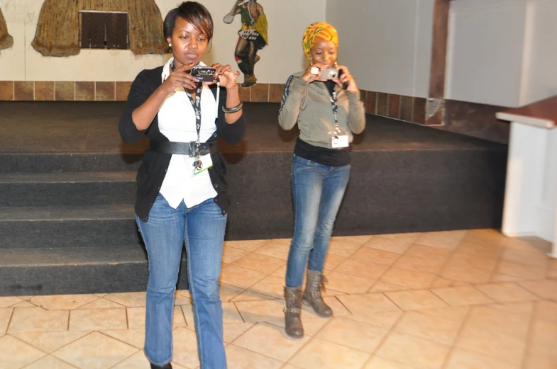 two women standing next to each other with cameras