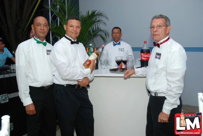 men standing in front of a bar holding wine glasses
