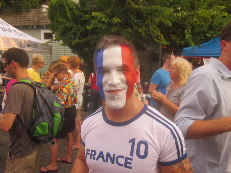 a man wearing a face paint stands outside