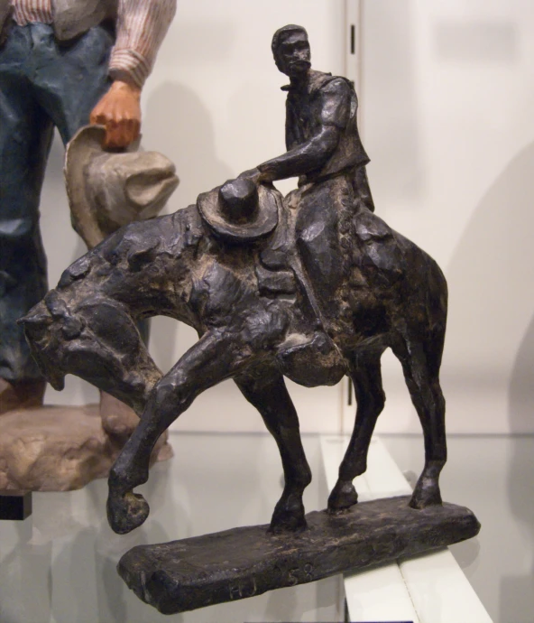 a man riding a horse statue next to another item