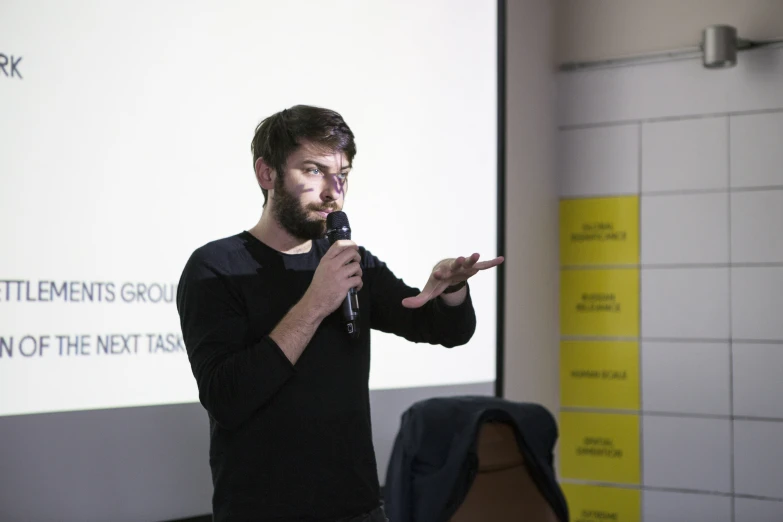 a man is giving a presentation while pointing