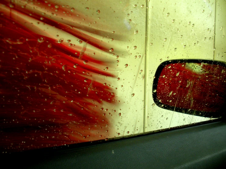 the side view mirror on a truck is covered in water