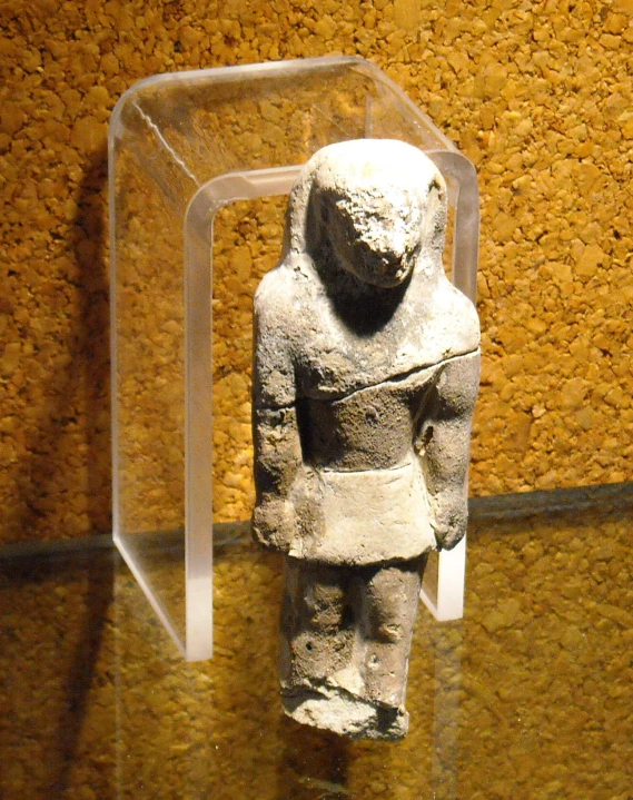 a statue is sitting on display in a glass case